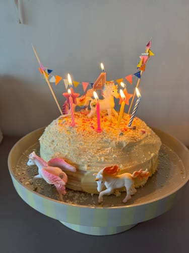 Klant presenteert een feestelijke verjaardagstaart op de by fonQ Arcade serveerschaal.