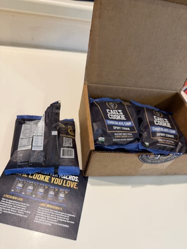 Customer's unboxing of Cael's Cookies, showing the dark packages in a box and an opened wrapper.