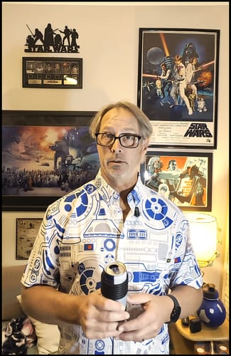 Customer wearing the white and blue R2 Deconstructed shirt in a room with Star Wars themed art on the walls.