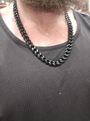 Customer wearing the thick, black Alpha Wolf Cuban Link Necklace against a dark shirt.