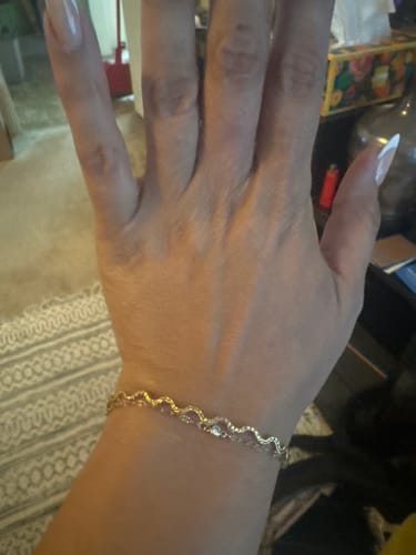 Customer wearing the wavy gold Meadow Bracelet on their wrist.