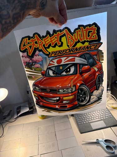 Customer holding a vibrant DTF transfer sheet with a red cartoon car graphic, created using the beginner DTF kit.