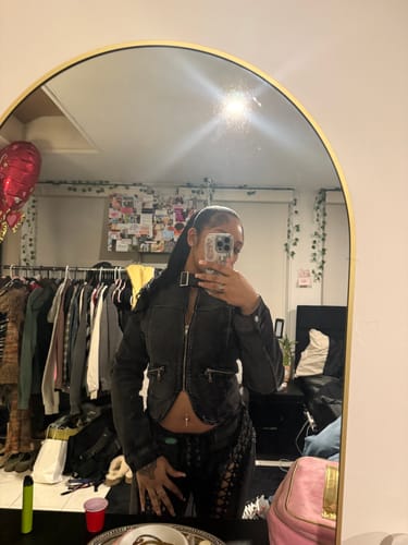 Customer shows off the black VILLAIN MOTO JACKET with its unique v-cut hem in a mirror selfie.