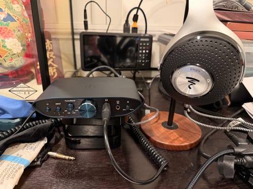 Customer's iFi Audio ZEN CAN Signature Headphone Amp on a desk, connected to a pair of over-ear headphones.