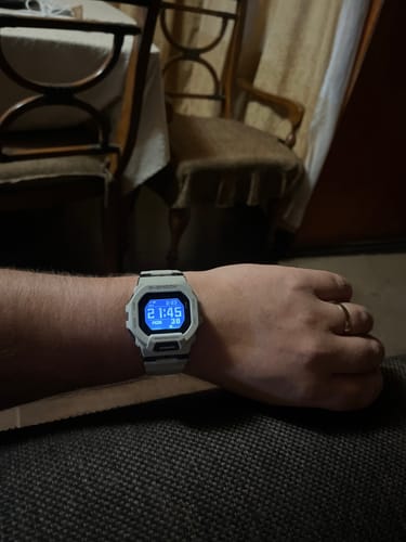 Cliente usando su reloj Casio G-Shock en la muñeca con la pantalla digital iluminada.