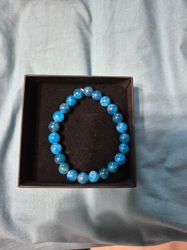 Avis d'un client : le bracelet Angélite aux perles bleues dans sa boîte de présentation noire.