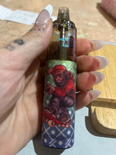 Customer holding a RandM Tornado 7000 disposable vape showing its colorful monkey graphic.
