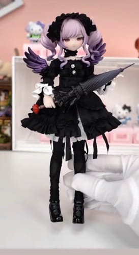 Customer holding a BJD doll with purple hair, a black dress, small wings, and a matching umbrella.
