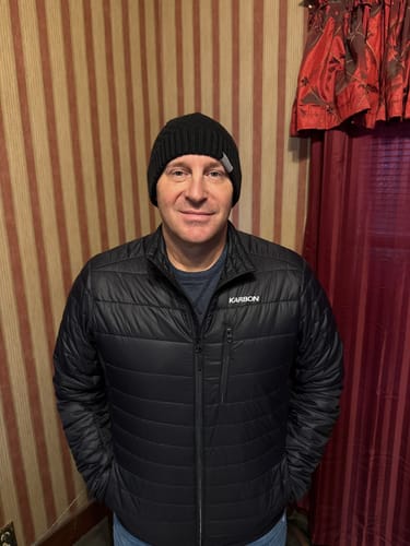 Customer wearing the black Maddy Hat, showing its simple, no-fold design.