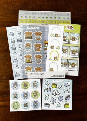 Reviewer's collection of Winter Highland Cows sticker sheets, including decorative washi tape and functional planner stickers.
