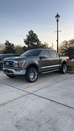 Reviewer's gray Ford F150 with a lifted stance after installing the 3" front leveling kit.