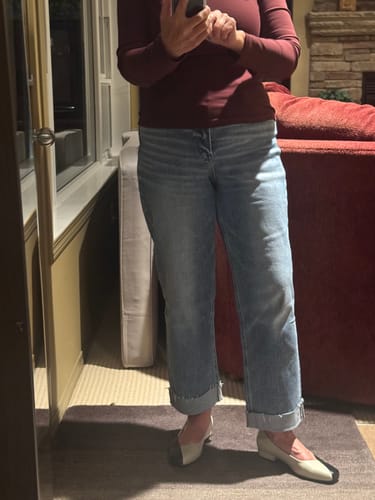 Reviewer wearing the mid-wash Sunny Days Slim Jeans with a rolled cuff, styled with flat shoes.