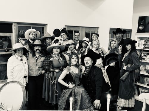 Reviewers in a group photo dressed in Wild West costumes for the murder mystery game.