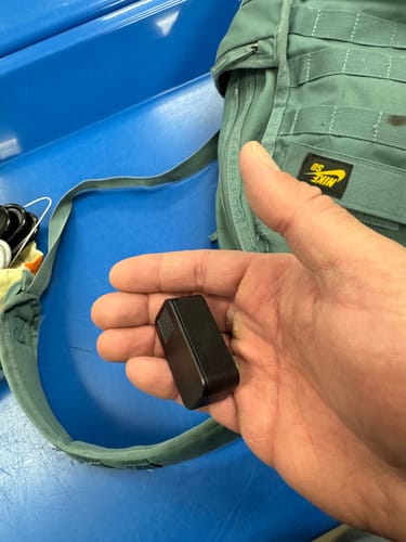 Customer holding the small black nano pill case in their palm to show its tiny size.
