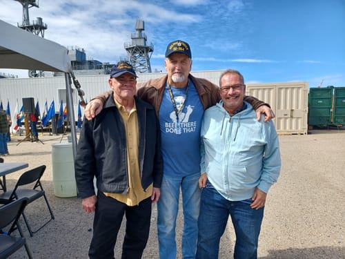 Reviewer wearing the blue 'Been There, Done That' t-shirt, standing with two men at an outdoor event.