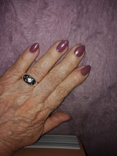 Die Hand einer Kundin mit gepflegten Nägeln, die mit dem glänzenden UV-Gel 'Berry Merlot' lackiert sind.