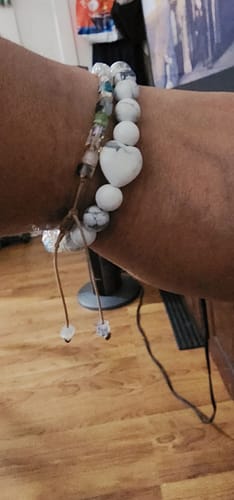 Close-up of a customer wearing a white howlite crystal bracelet with a heart-shaped bead on their wrist.