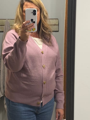 Reviewer in a mirror selfie wearing the lavender Waffled Body Button Accented Cardigan over a white top and jeans.