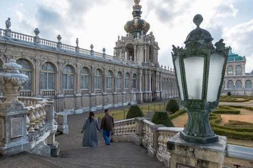 A reviewer's heartfelt photo showing a couple holding hands and walking near an ornate building.