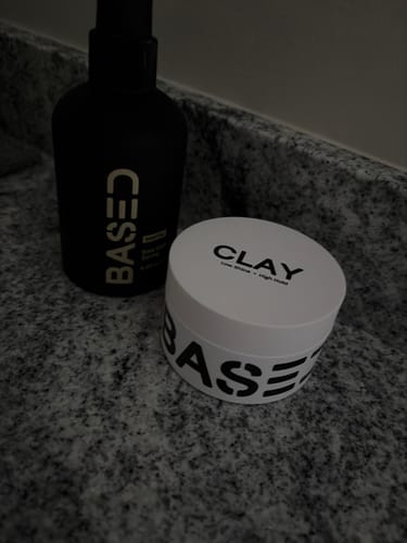 Customer's Texture & Hold Duo, showing the black spray bottle and white clay tub on a dark granite countertop.