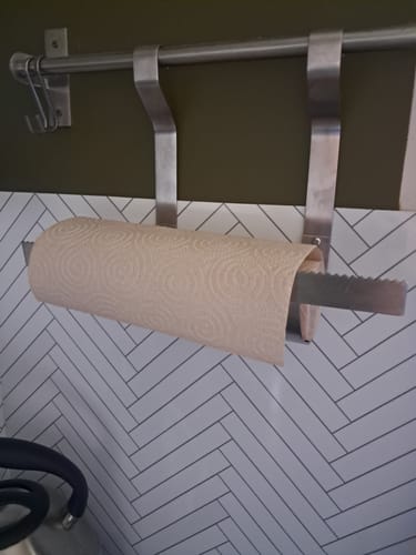 Client montrant le rouleau épais d'essuie-tout ultra-absorbant sur un support mural.