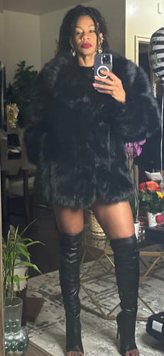 Reviewer posing in a mirror wearing the elegant black Faux Mink Pelted Coat.