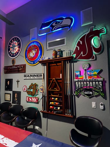 Customer's Seattle Seahawks Super Bowl wall art with bright LEDs, mounted on a fan cave wall among other signs.