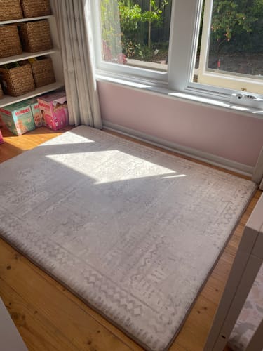 Reviewer's Sandstone Haze Mellow Mat on the wooden floor of a sunlit nursery.