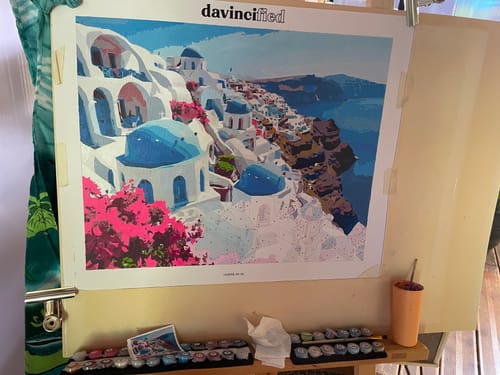 Reviewer's partially completed Santorini Blue Domes paint by numbers kit displayed on an easel.