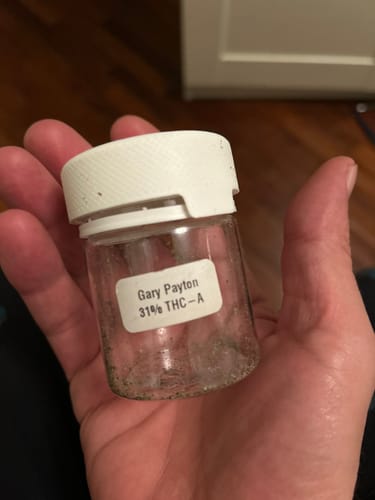 Customer holding the empty clear jar for Gary Payton 31% THCA, with the label visible.
