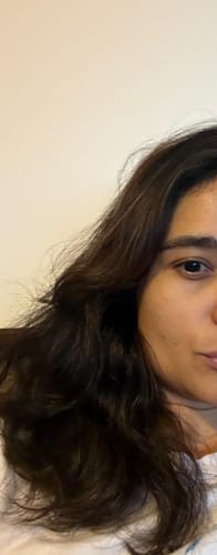 Cliente mostrando o efeito do tratamento SHRP em seu cabelo ondulado, que está alinhado e com menos frizz.