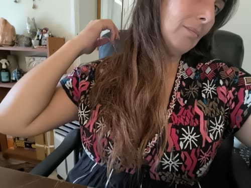 Cliente muestra su cabello suave y desenredado después de usar el Spray Bifásico.