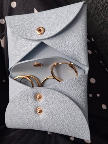 Customer's light blue Everyday Pouch shown open with gold hoop earrings inside.