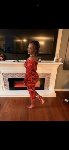 Reviewer posing in the red floral Bare Body Off-Shoulder Midi Dress with matching red heels.