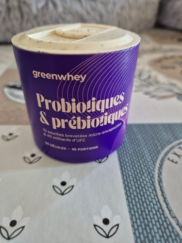 Client montrant le pot violet de Probiotiques & Prébiotiques posé sur une table.