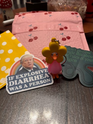 Reviewer's dark, wavy sticker about religion shown with other items from their order.