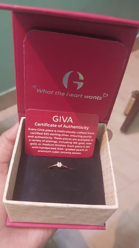 Customer holds the open pink box showing the Golden Lovely Floret Ring and its certificate of authenticity.