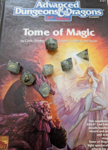 Customer's Prehnite gemstone dice set displayed on the cover of an Advanced Dungeons & Dragons book.
