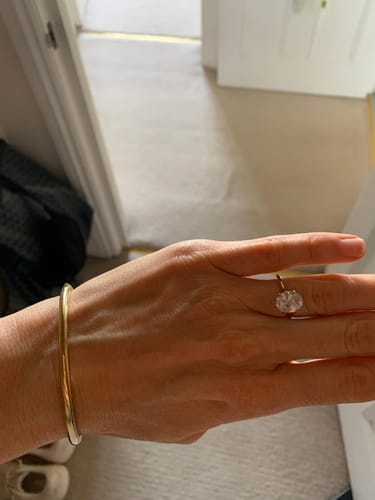 Customer showing the Oval Solitaire Travel Ring on their hand indoors.