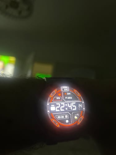 Close-up of a reviewer's digital watch face illuminated in the dark, showing the battery at 35%.