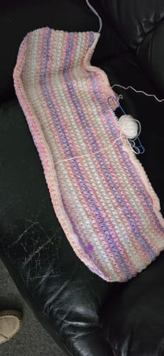 Reviewer's knitting project in progress, showing the soft, striped yarn from the February Baby Girl Mystery Knitting Box.