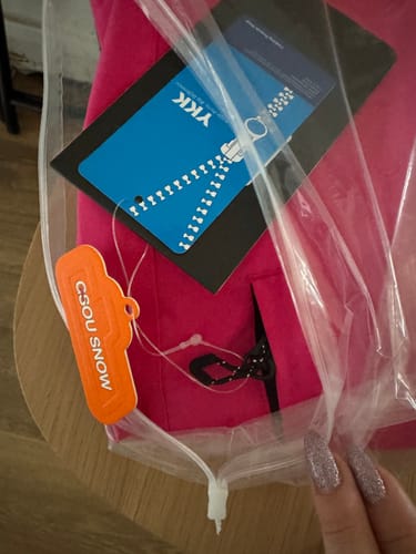 Customer holding their new rose snow pants in the original packaging with tags attached.