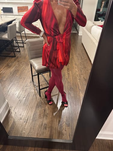 Reviewer wearing glossy, berry-colored PLAY seamless tights with a red dress in a mirror selfie.