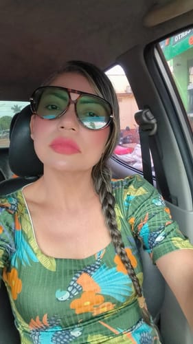 Avaliadora usando os óculos Tropea Edição Limitada com armação tartaruga, em uma selfie dentro de um carro.