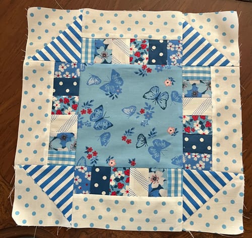 Customer's quilt block project from the Mrs Quilty Subscription Box, showing blue and white butterfly and polka dot fabrics.