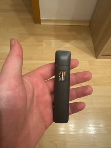 Ein Rezensent hält den kompakten THC Melon Kush Vape in der Hand.