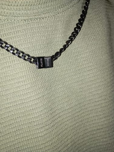 Close-up of a customer wearing the Legacy Necklace with two black beads engraved with the names 'Flavie' and 'Lucie'.