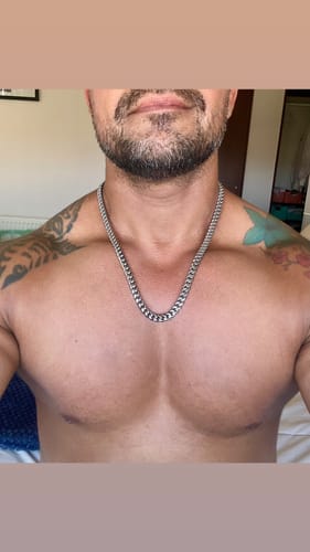 Cliente mostrando cómo le queda la Cadena Cuban Link de 8mm en el pecho.