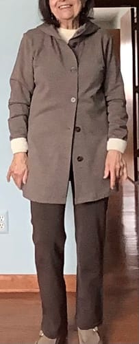 Reviewer standing indoors wearing the Simply Taupe Edna Hooded Cardigan, showing its long, hip-covering fit.