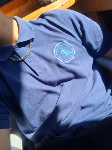 Opinador luciendo la Cadena Cuban Link de 8mm sobre una camisa polo azul.